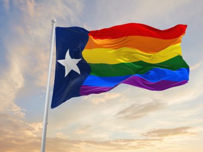 Texas pride flag waving in the wind at cloudy sky. Freedom and love concept. Pride month.